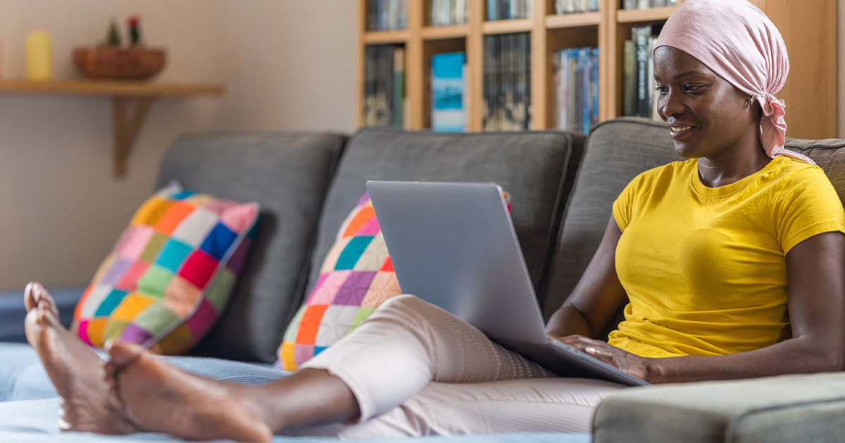 Person using laptop on a couch Person using laptop on a couch