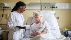 Healthcare provider talking to patient in a bed Healthcare provider talking to patient in a bed
