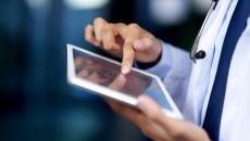 Clinician looking at a tablet computer Clinician looking at a tablet computer