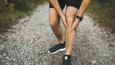 Person holding onto their leg while in the wilderness Person holding onto their leg while in the wilderness