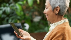 A smiling elderly person using a smartphone A smiling elderly person using a smartphone