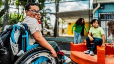 Student in a wheelchair on a playground Student in a wheelchair on a playground
