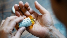 Person holding a pill bottle and pouring medication into their hand Person holding a pill bottle and pouring medication into their hand