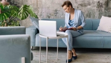 Person sitting on a couch while looking at a computer Person sitting on a couch while looking at a computer