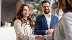 Businesswomen shaking hands during a meeting with a businessman Businesswomen shaking hands during a meeting with a businessman