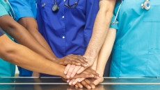 Healthcare providers putting their hands together in unification