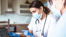 Healthcare provider sitting next to a patient while both are looking at a computer