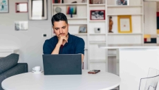Person on a laptop while sitting at a table