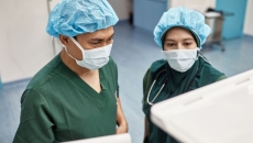 Two healthcare providers looking at computers