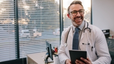 Physician holding a stethoscope and a tablet computer Physician holding a stethoscope and a tablet computer