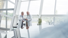 Two healthcare researchers speaking with each other Two healthcare researchers speaking with each other