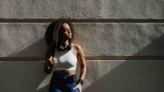 Person wearing a glucose monitor while standing against a wall Person wearing a glucose monitor while standing against a wall