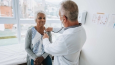 Doctor listening to a patients heart with a stethoscope Doctor listening to a patients heart with a stethoscope
