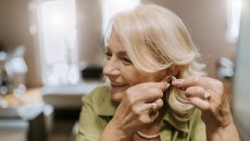 Person putting in a hearing aid Person putting in a hearing aid