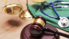 A gavel next to a scale and a stethoscope A gavel next to a scale and a stethoscope