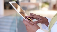 Someone holding a tablet near their torso Someone holding a tablet near their torso