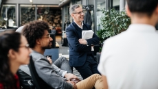 Several people sitting in a courtyard looking away from the camera Several people sitting in a courtyard looking away from the camera