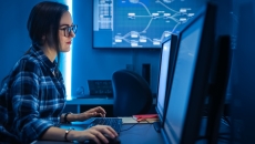 Person sitting at a computer while in a dark room Person sitting at a computer while in a dark room