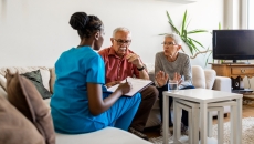 Two people sitting on a couch talking to a healthcare provider who is sitting on a different couch Two people sitting on a couch talking to a healthcare provider who is sitting on a different couch