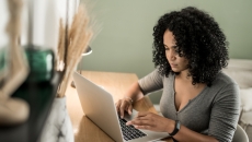 Person sitting at a desk and typing on a computer Person sitting at a desk and typing on a computer