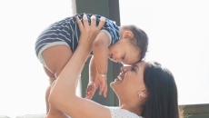 person holds infant in arms Person holds infant in arms