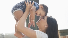 One person holding another person above their head One person holding another person above their head
