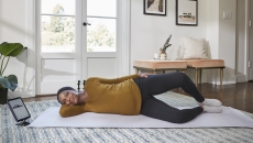 A woman doing a pelvic floor exercise while using Hinge's app on a tablet A woman doing a pelvic floor exercise while using Hinge's app on a tablet