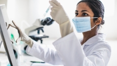 Lab technician examining contents of a test tube Lab technician examining contents of a test tube