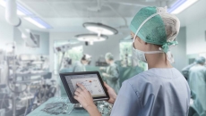 Surgeon in operating room looking at tablet Surgeon in operating room looking at tablet