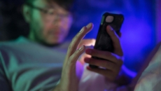 A man using a smartphone at night. A man using a smartphone at night.