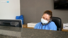 healthcare worker in mask using a phone at a desk