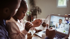 Two people conferring with a healthcare professional via a laptop computer Two people conferring with a healthcare professional via a laptop computer