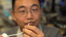 A researcher holding a small-scale surgical robot A researcher holding a small-scale surgical robot