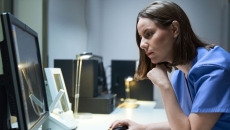 A doctor looking at imaging results on a desktop computer. A doctor looking at imaging results on a desktop computer.