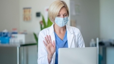 A doctor recording a video on her laptop. A doctor recording a video on her laptop.