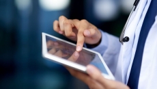 A close-up of a doctor using a tablet. A close-up of a doctor using a tablet.