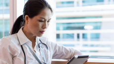 A clinician using a tablet. A clinician using a tablet.