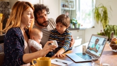 A family talking to a doctor through a video chat on a laptop. A family talking to a doctor through a video chat on a laptop.