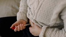 A close up of a person injecting fertility medication into their abdomen A close up of a person injecting fertility medication into their abdomen