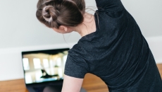 A person following a video stretch routine on their laptop A person following a video stretch routine on their laptop