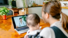 A mother and baby on a video call with a doctor. A mother and baby on a video call with a doctor.