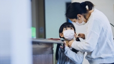 A mom checks a child's temperature before he goes to school A mom checks a child's temperature before he goes to school