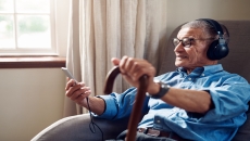 An older man using a smartphone at home. An older man using a smartphone at home.