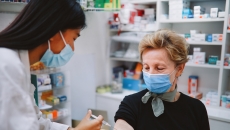 An older woman getting a shot from a pharmacist An older woman getting a shot from a pharmacist