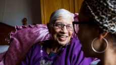 An older woman sitting with a younger woman at home. An older woman sitting with a younger woman at home.