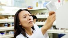 A pharmacist pulling a medication off a shelf A pharmacist pulling a medication off a shelf