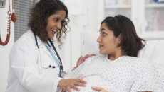 A pregnant woman talking with a doctor in a hospital. A pregnant woman talking with a doctor in a hospital.