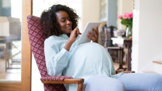 A pregnant woman using a tablet A pregnant woman using a tablet