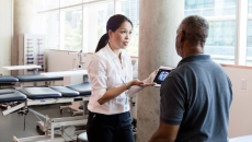 A medical professional uses a digital tablet to explain brain injury and recovery to a person after his stroke. A medical professional uses a digital tablet to explain brain injury and recovery to a person after his stroke.