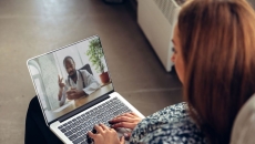 A woman talking to a doctor via telehealth using her laptop A woman talking to a doctor via telehealth using her laptop